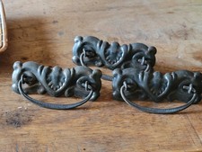 Vintage ornate cast iron hardware, potentially Victorian-style drawer pulls