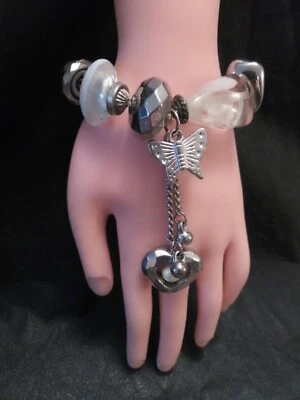 BRACELET FANTAISIE AVEC GROS BRELOQUES ARGENTES et BLANCS SUR ELASTIQUE Occ. TBE - Photo 1/4