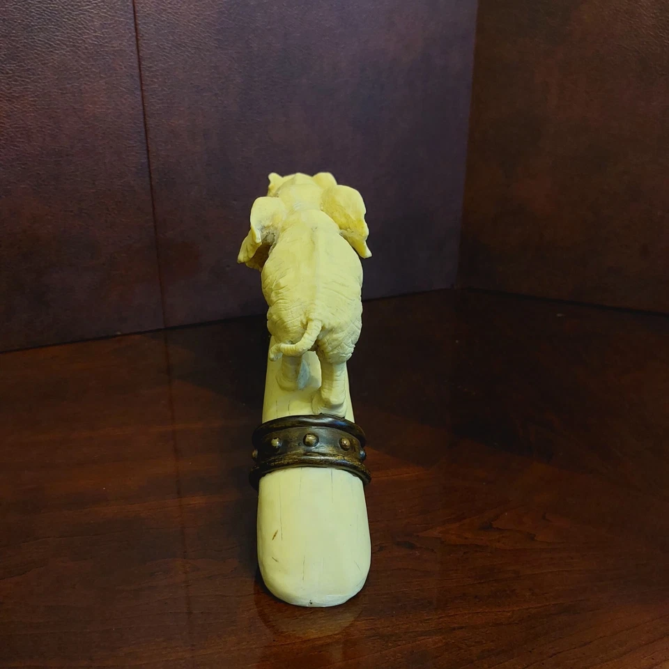 Escultura familiar de elefantes, ternero, mamá y papá caminando sobre puente formas como un colmillo Foto 3 de 4