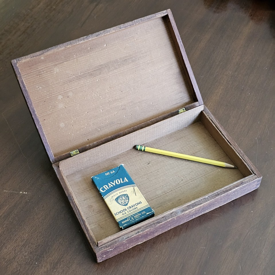 A vintage Crayola No. 6A box paired with a carved wood box — a curated nostalgia desk vignette that looks like something from a design magazine.