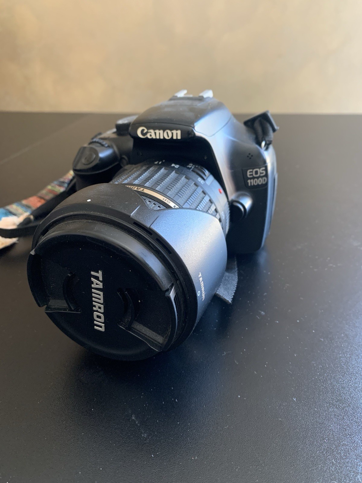 Canon EOS 1100D SLR digitale nera con obiettivo Tamron AF 17-50mm e tracolla