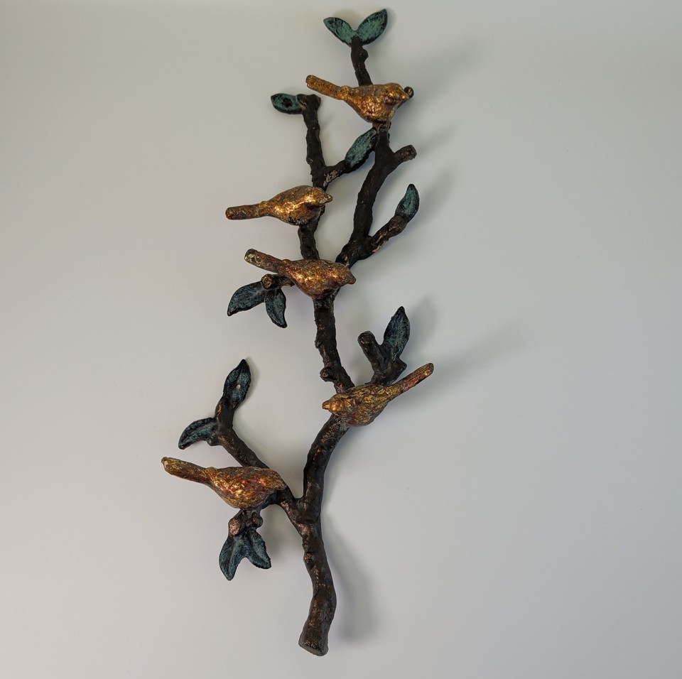 A hefty 24-inch cast iron birds-on-a-branch wall sculpture from the 1960s — weighty, artisanal, and strikingly graphic against a bare wall.