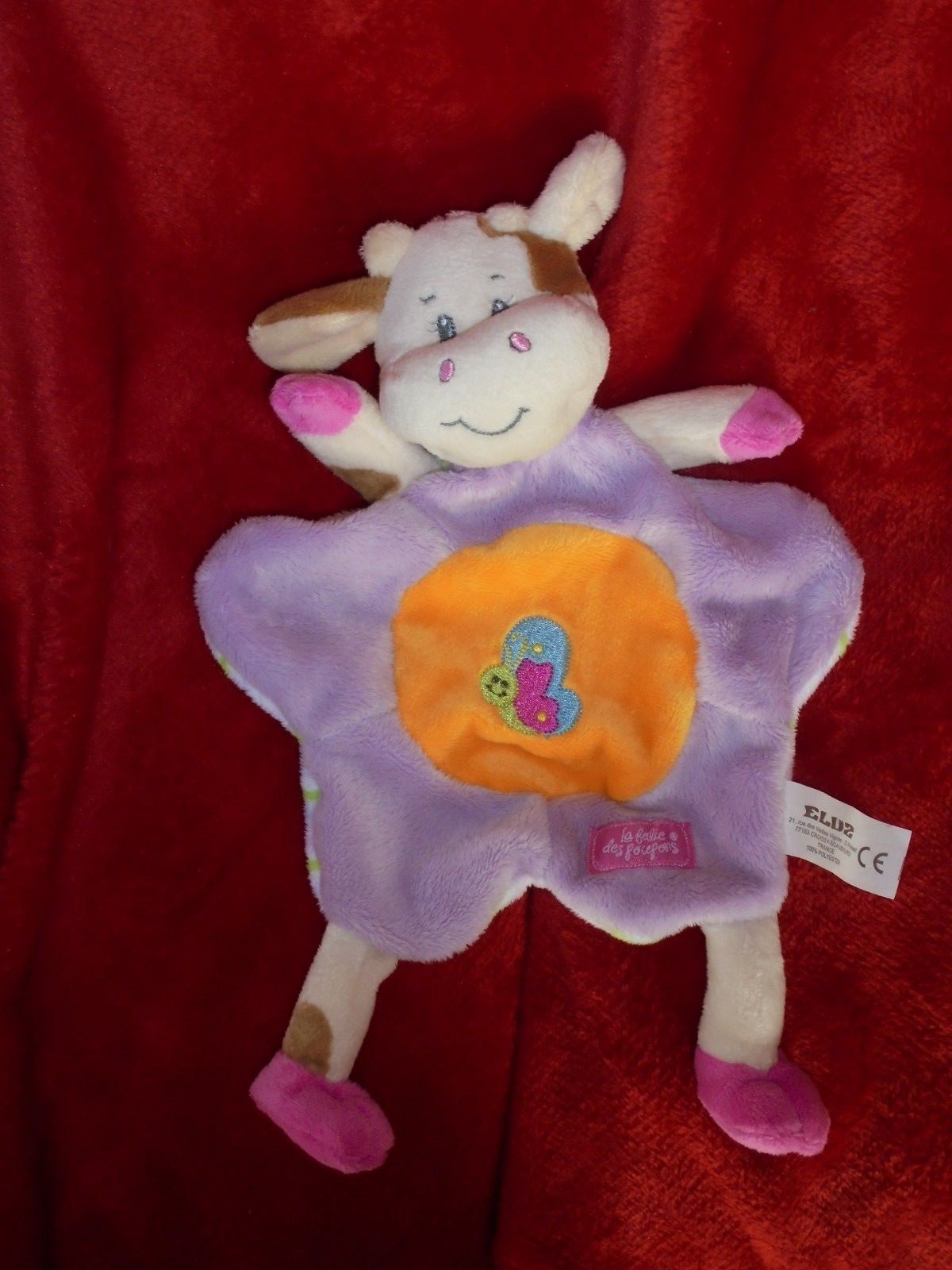 Doudou plat vache ELUZ le complice violet et orange des nuits de bébé