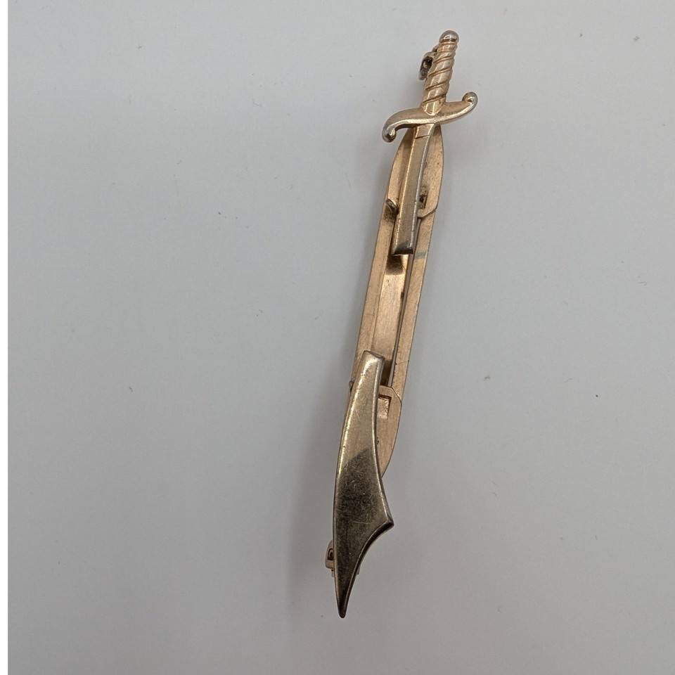 A vintage Anson gold-tone sword-and-scabbard tie clip — a tiny wearable weapon of pure menswear personality that no modern accessory brand is making.