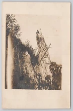 Real Photo Postcard People Sitting atop Tall Rocks Mountain RPPC