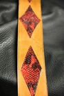Black leather guitar strap with two red diamond inlay segments and visible stitching, all hand made in USA.