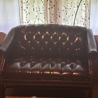 A Dark Burgundy Office Leather Sofa With Sturdy Arms And A Matching Chair