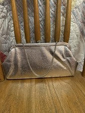 Vintage silver metallic evening clutch W/ a textured finish silver chain strap.