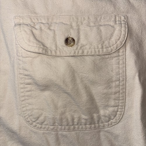 White vintage flannel button-down shirt with large front pocket, brown button closure, and visible stitching.
