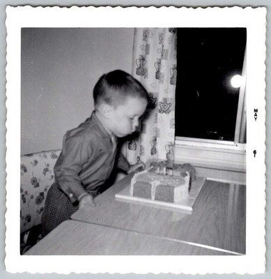 Vtg B&W Snapshot Young Boy Blowing Out Birthday Cake Candles Home Party 1961