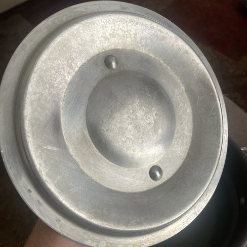 Worn silver metal 2.5 quart double boiler insert with embossed logo, mounted by two metal rivets on a dark surface.