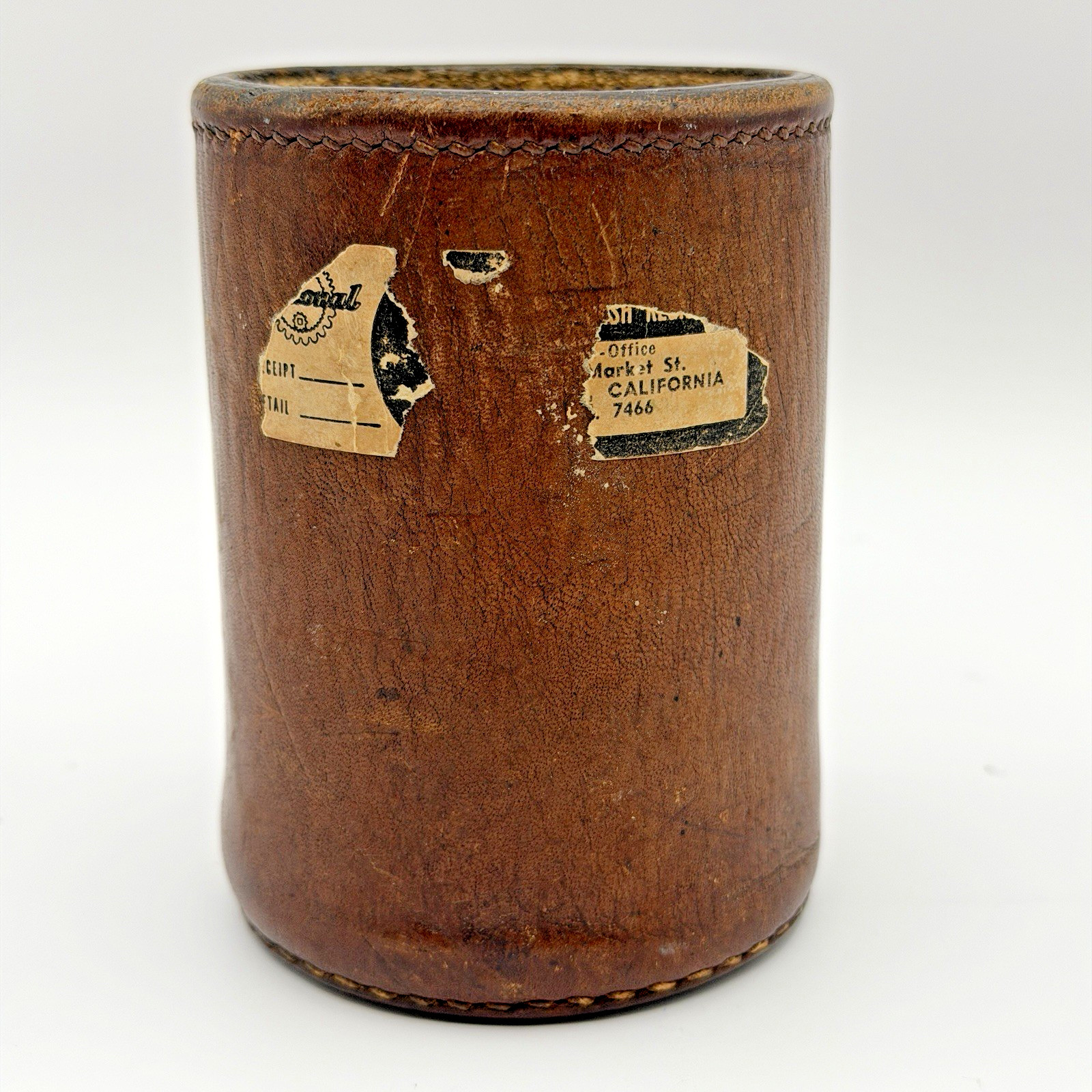 A fabric-lined leather dice cup shaker with aged patina, stamped San Francisco Market Street.