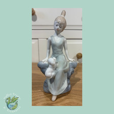 Vintage porcelain figurine of a lady with a dog jumping on her leg