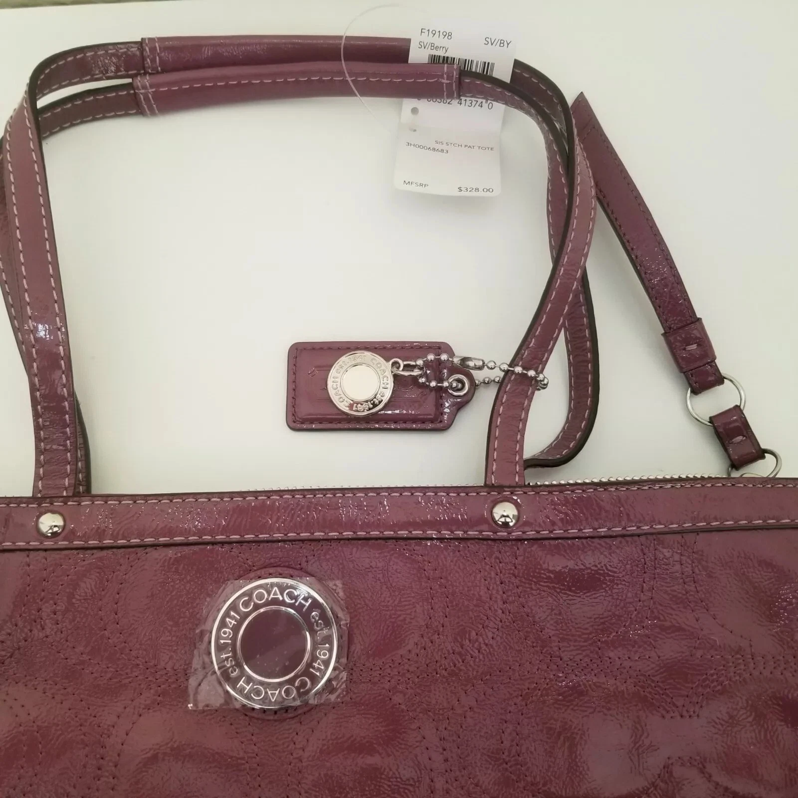 Borsa a tracolla Coach Signature in pelle verniciata rosa bacche goffrata magenta