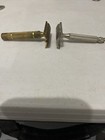 Two vintage Gillette safety razors, one brass and one silver, with flat rectangular handles and visible branding.