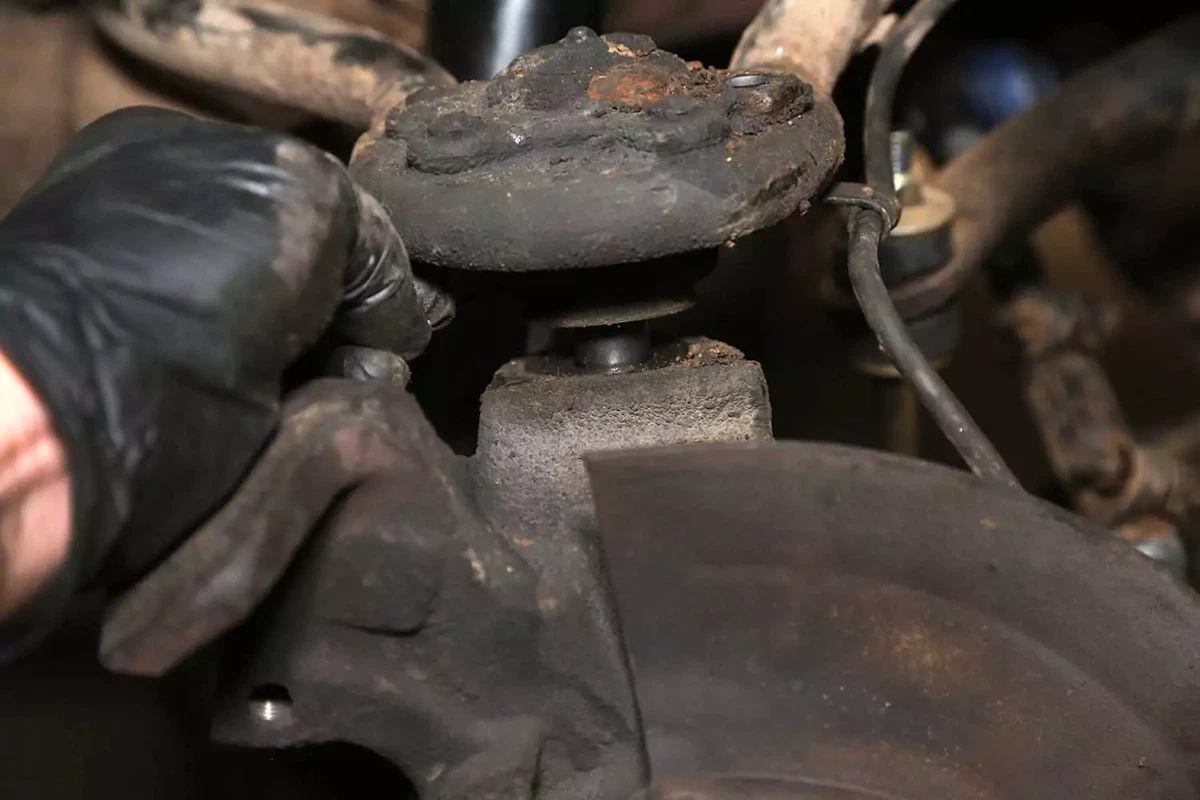 The upper ball joint is dropped from the knuckle.