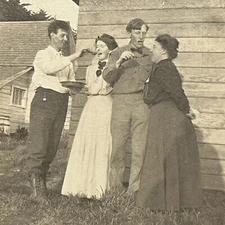 Antique RPPC Real Photograph Postcard Men Spoon Feeding Women Outside Odd