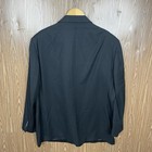Black men's blazer jacket with notch lapels, three-button front closure, and long sleeves, hanging on wooden hanger.