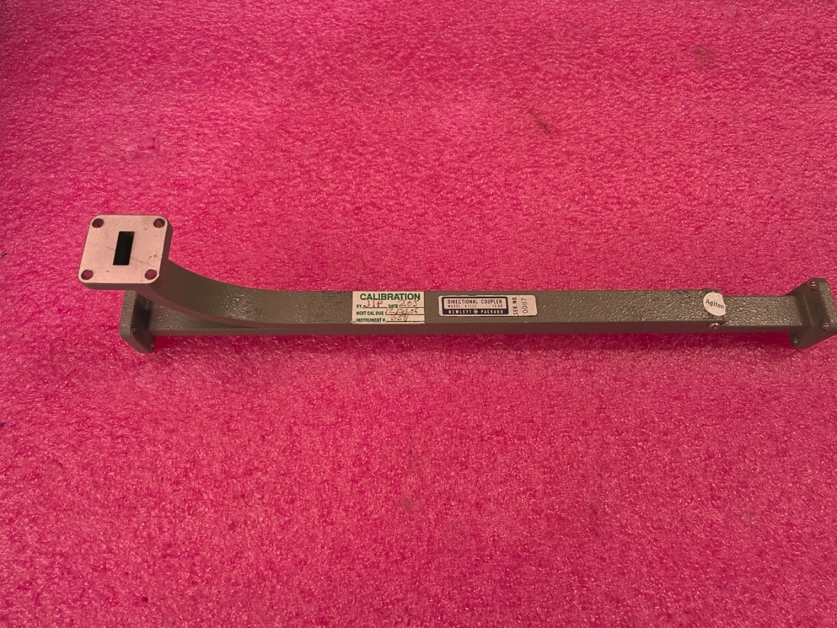 HP/Agilent K752C WR42 waveguide directional coupler unit #1 with black calibration marker and silver connector end on red surface.