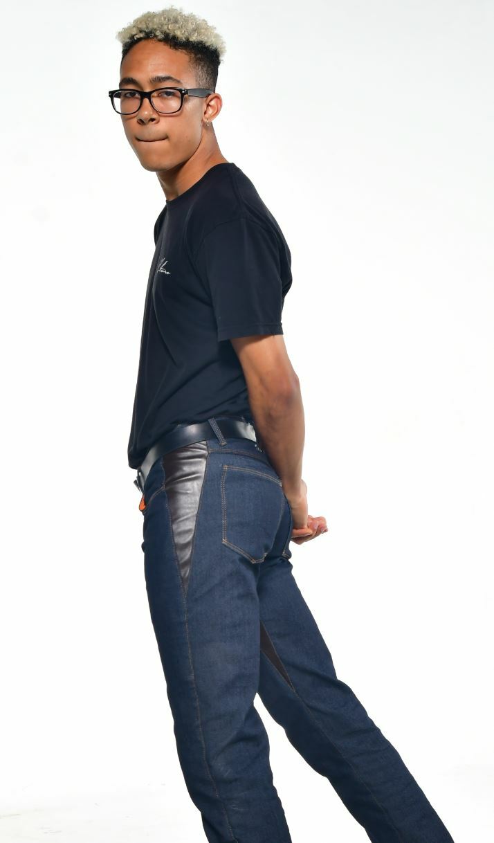 Person wearing black denim men's bootcut jeans with light gray front and dark brown leather back, standing upright.