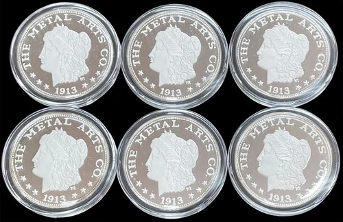 (6) 1913 DATED MORGAN THE METAL ARTS COMPANY 1 OZ 999 FINE ROUNDS IN CAPSULES