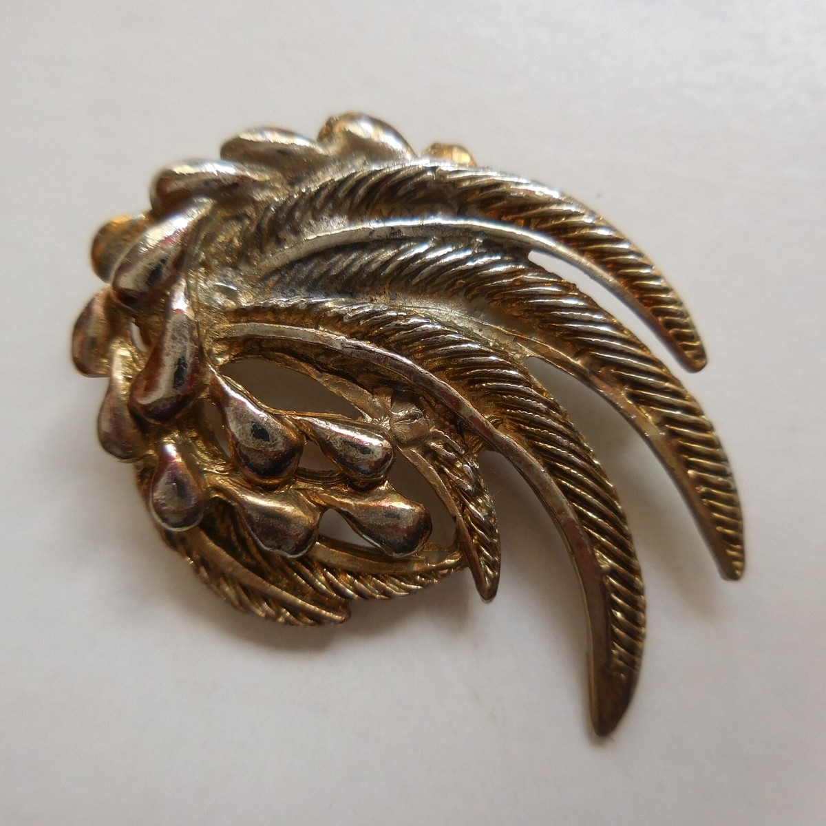 P## Broche fantaisie vintage détaillée en métal doré, française