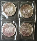 Four 1986 1oz Silver World Trade Unit Rounds in Plastic