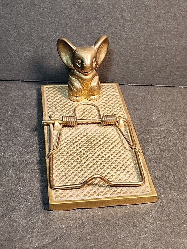 A brass mouse caught in a mousetrap — used as a paper clip holder — is darkly clever desk art that nobody else will have.