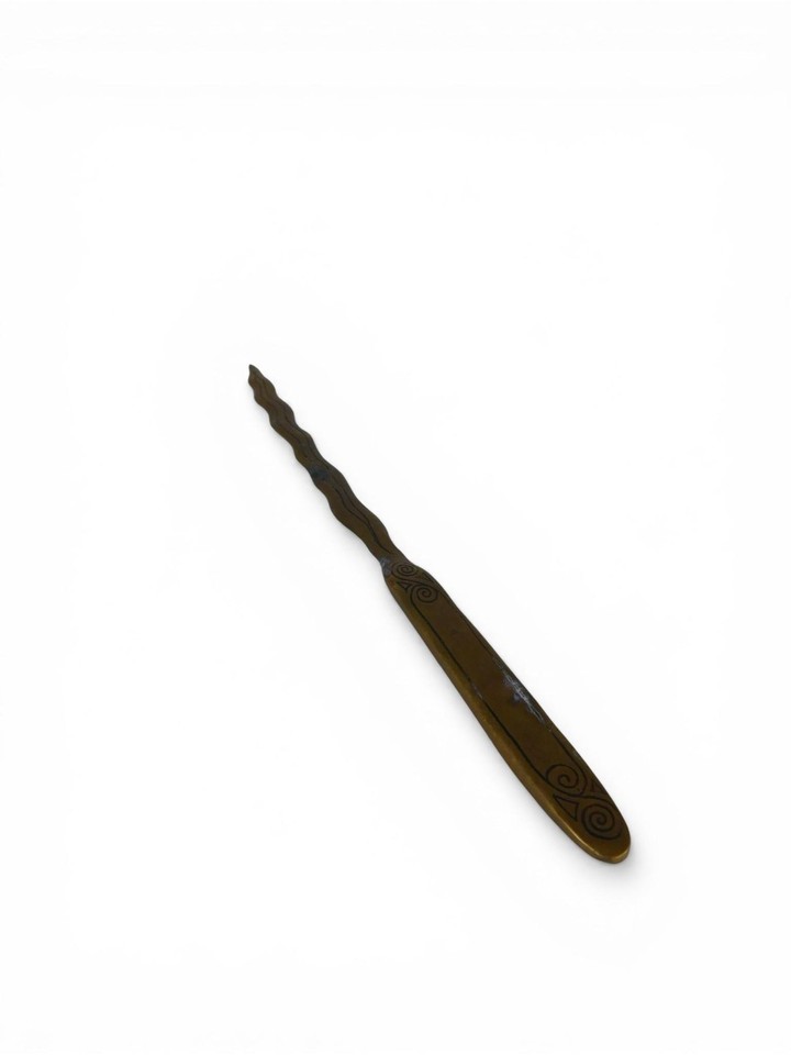 A sinuous brass snake doubling as a letter opener — equal parts art object and functional desk tool with serious Victorian-curiosity-cabinet energy.