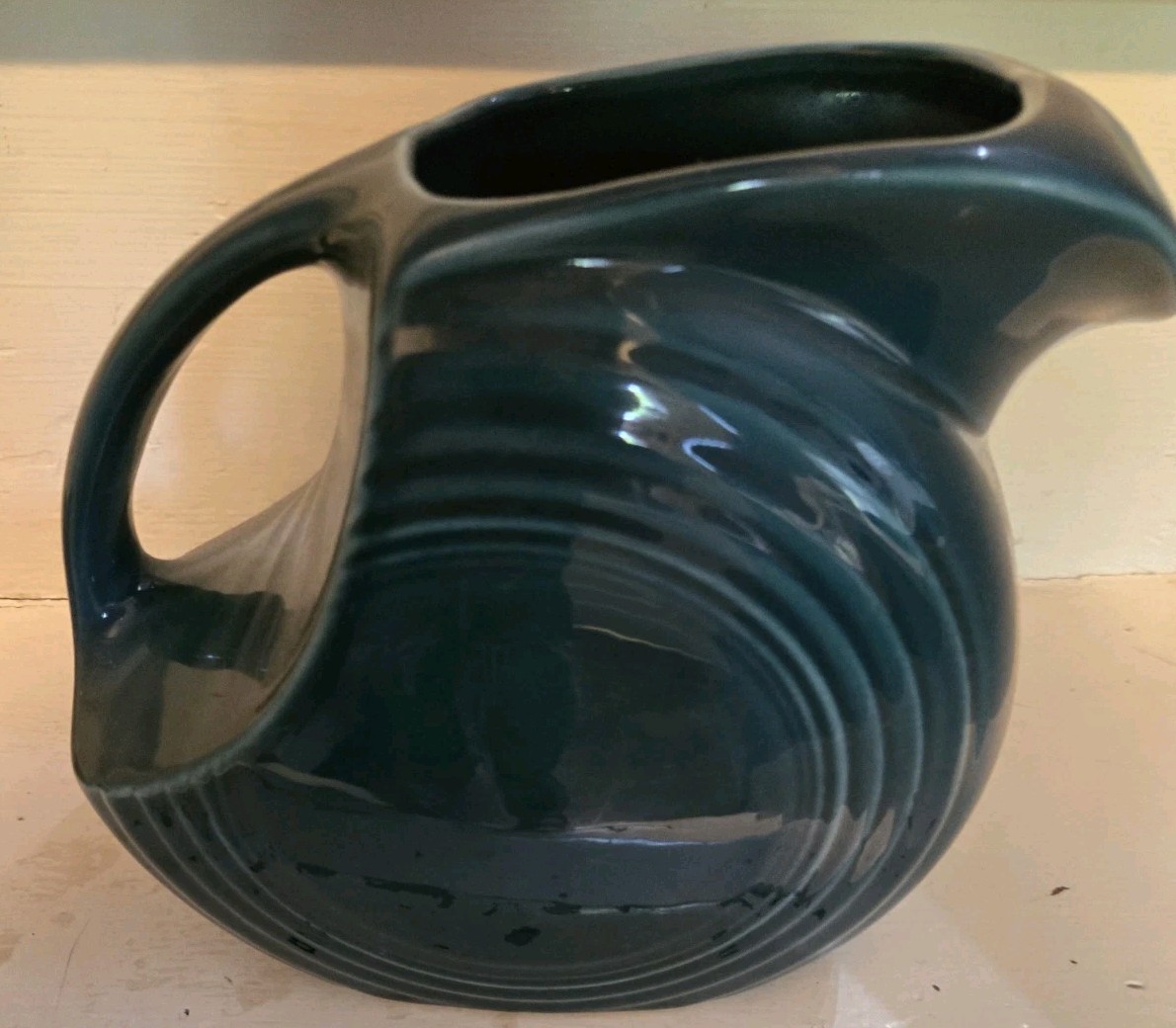 Dark teal Fiesta ceramic disk pitcher with ring handle