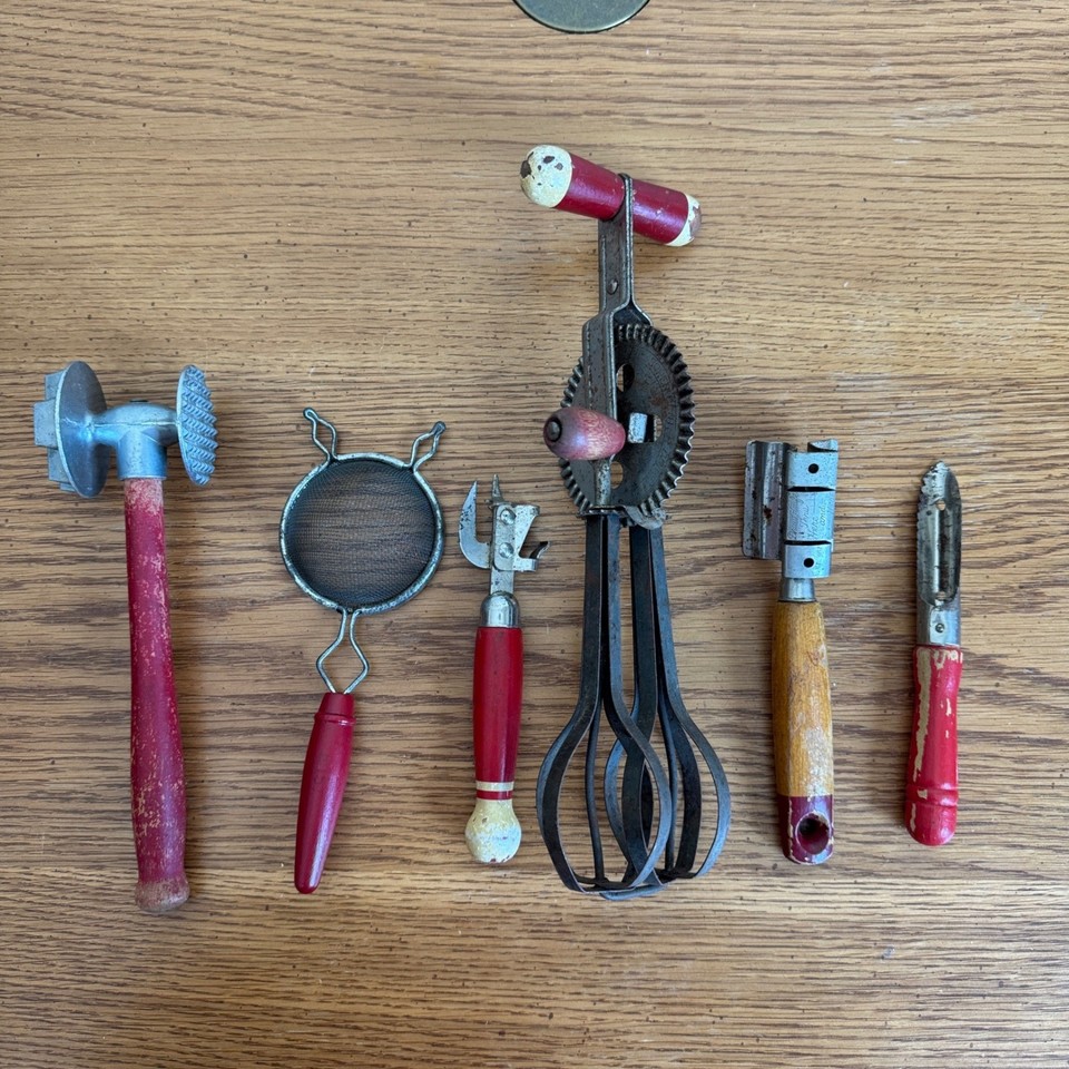 A matching red wood-and-metal vintage utensil set — the kind of retro kitchen aesthetic people pay decorators to recreate.