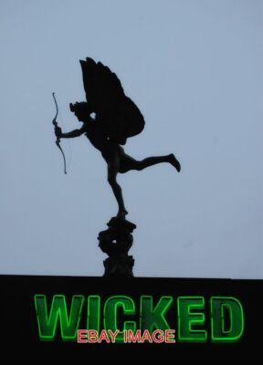 PHOTO  WICKED EROS PICCADILLY'S FAMOUS STATUE ABOVE AN AD FOR THE MUSICAL 'WICKE