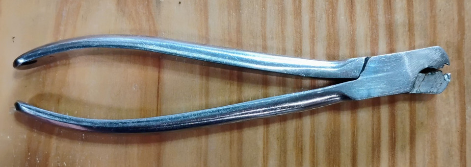 Tiny, beautifully precise watchmaker's bow-closing pliers — a piece of horology history that doubles as a stunning conversation-starter desk curiosity.