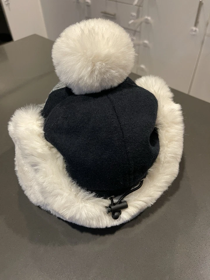 knitted winter hat with a visor and white faux fur ear muffs and pom-pom New - Image 2 of 4