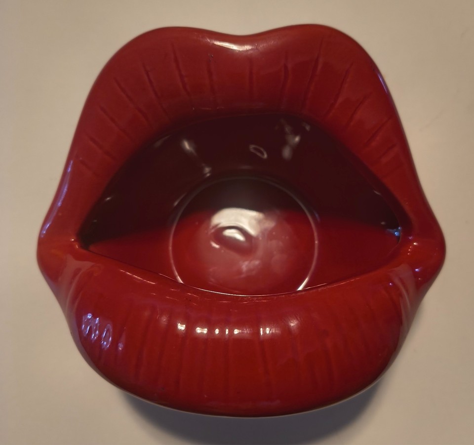 Bold pop-art red lips sculptural dish that works as an ashtray, trinket tray, or planter — equal parts kitschy and genuinely striking as desktop or vanity decor.