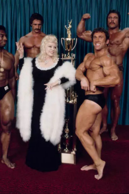 Mae West posing with bodybuilders while promoting the film Sextett- 4x6 Photo