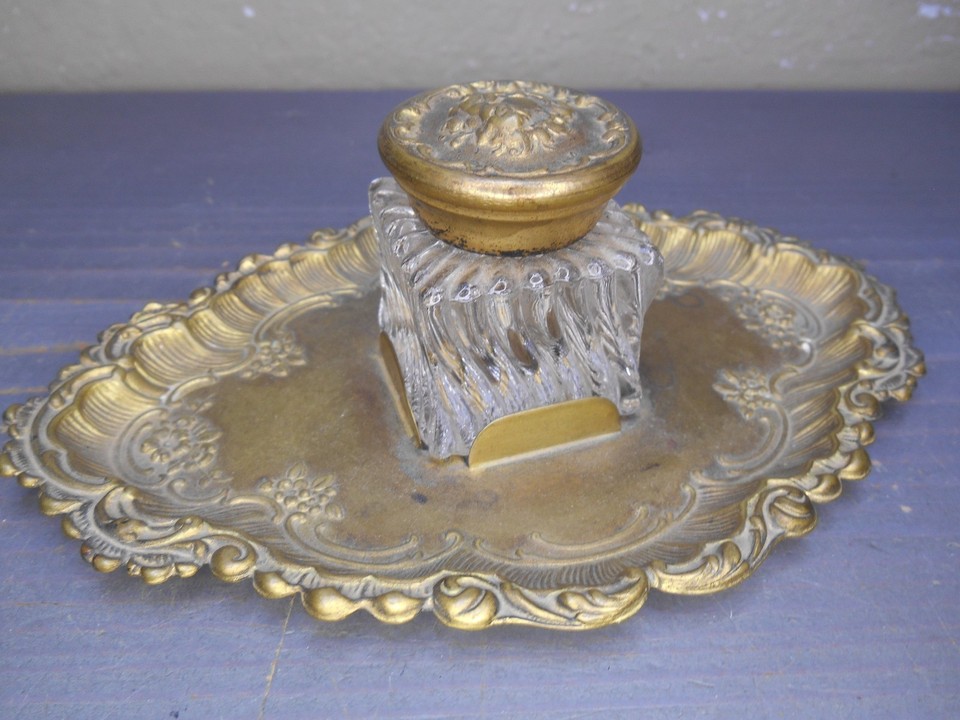 An ornate Art Nouveau inkwell with its original glass insert — a functional antique that makes writing feel like a 19th-century ceremony.