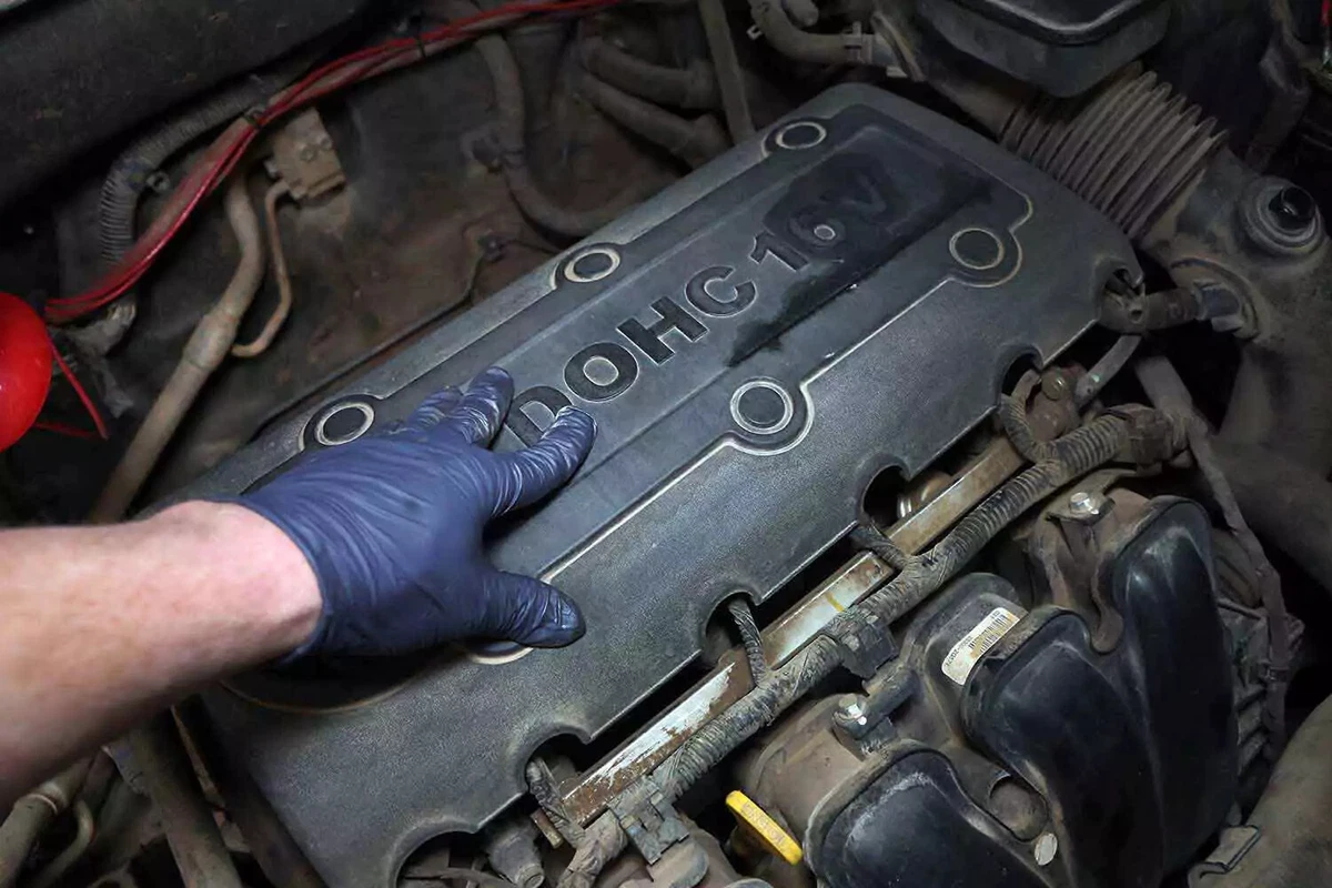 Mechanic replacing plastic engine cover.
