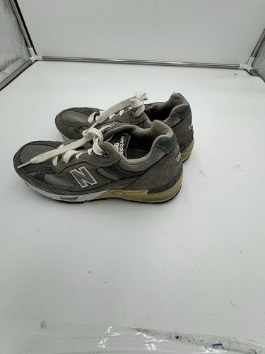 Grey dark grey New Balance 991 sneakers size 7 with white laces, tan insoles, and “Made in USA EUC” text on side.