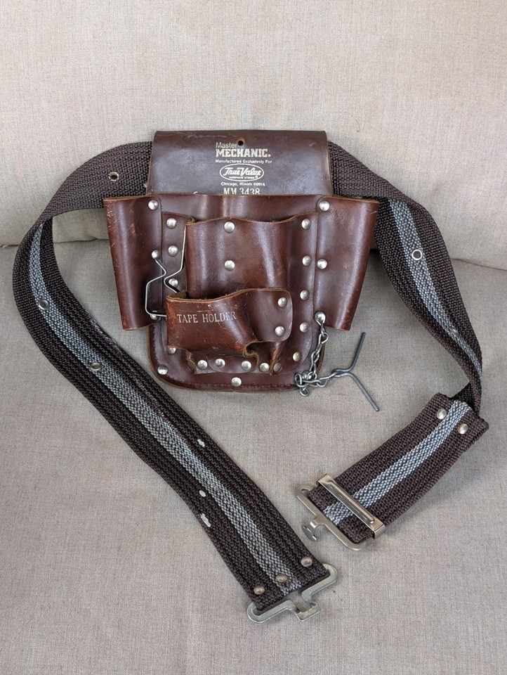 A rugged vintage leather tool pouch with original web belt — looks like it came straight off a WWII-era workbench and is cooler than any modern version.