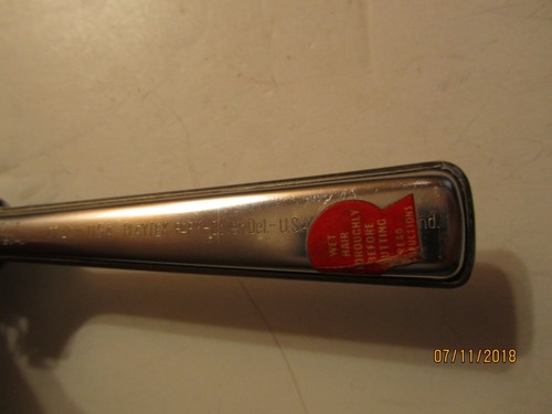 Silver Playtex hair cutter with red “Made in U.S.A.” label and black handle featuring visible branding and text.