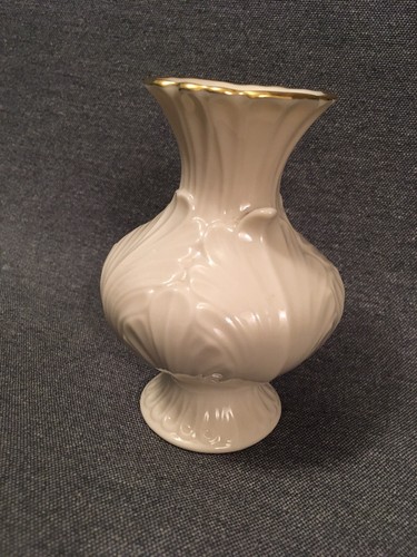 Cream Made in the USA 24K Lenox vase with scalloped rim and embossed swirling vine design on a gray background.