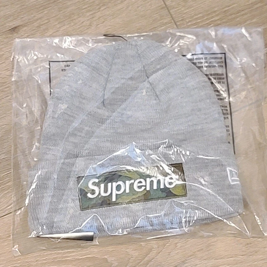 Boîte Supreme x New Era logo Beanie FW23 gris bruyère camouflage bogo   EN MAIN