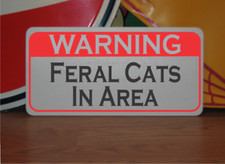Señal metálica de advertencia de gatos salvajes en el área