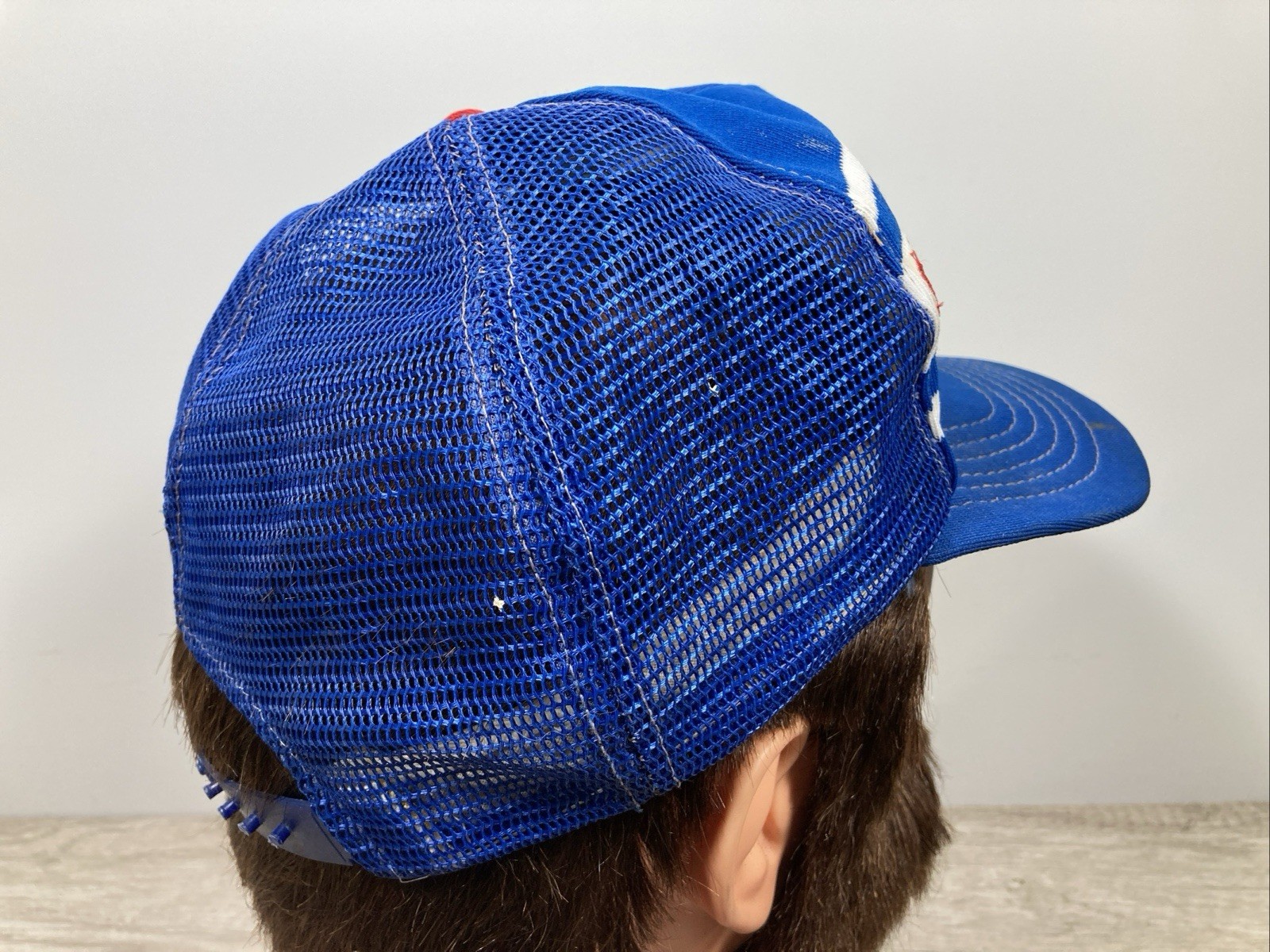 Blue US-made wide-stripe trucker hat with white and red shoulder panels and embroidered “VTG Chicago Cubs” text on front.