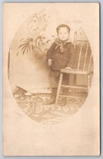 Portrait of Toddler Boy Standing By The Chair Real Photo RPPC Postcard