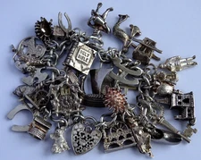 Vintage heavy solid silver charm bracelet &many curious silver charms inc moving