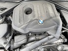 Black BMW 430I engine with silver top, dual exhaust pipes, and blue BMW logo on side.