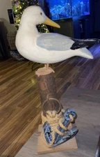 Hand-painted decorative seagull figurine on a nautical-themed post