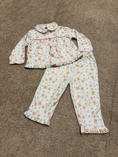 Vintage pair of children's pajamas featuring a Winnie the Pooh  floral pattern.